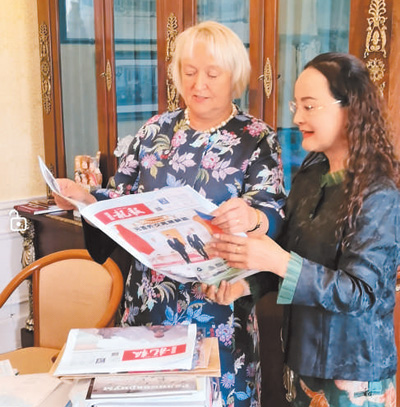 李雙杰（右）向俄羅斯友人展示《龍報》。